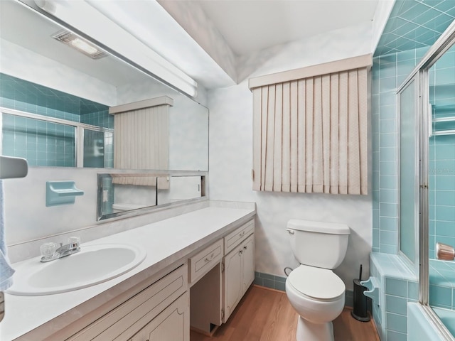 full bathroom with shower / bath combination with glass door, wood-type flooring, vanity, and toilet