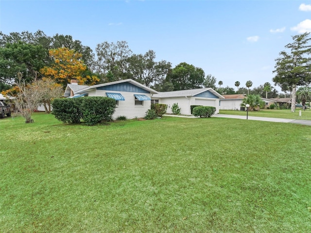 ranch-style home featuring a garage and a front lawn