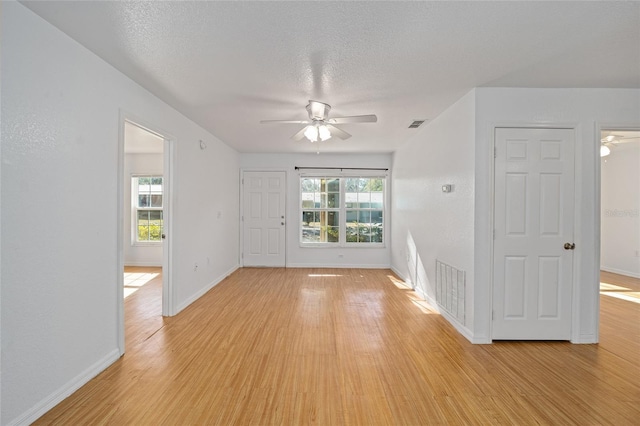 spare room with plenty of natural light, light hardwood / wood-style floors, and ceiling fan