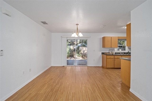 kitchen featuring light wood-type flooring, a wealth of natural light, and a chandelier