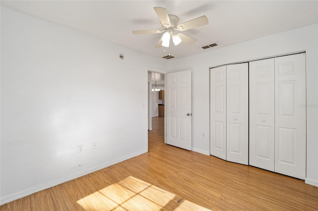 unfurnished bedroom with a closet, light hardwood / wood-style floors, and ceiling fan