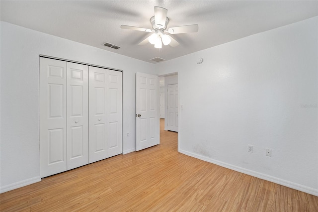 unfurnished bedroom featuring ceiling fan, a closet, and light hardwood / wood-style flooring