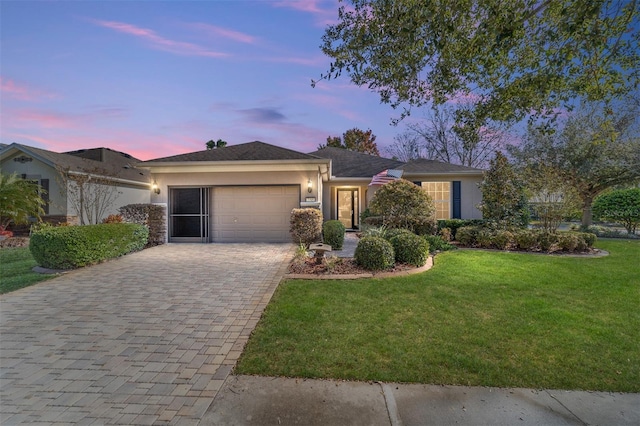 single story home with a garage and a yard