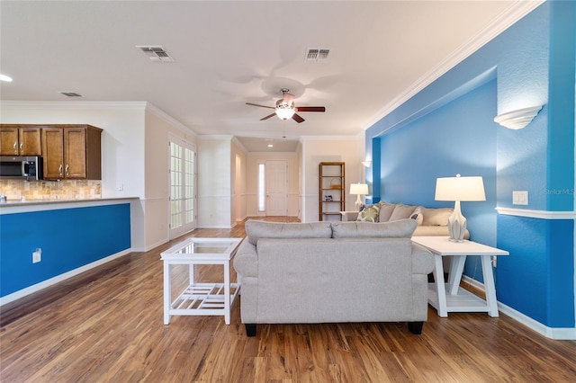 living room with ceiling fan, dark hardwood / wood-style flooring, and ornamental molding