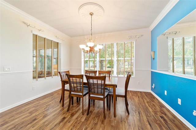 dining room with hardwood / wood-style flooring, plenty of natural light, crown molding, and a notable chandelier