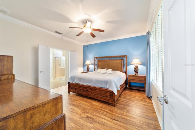 bedroom featuring light wood-type flooring, ensuite bathroom, ceiling fan, and ornamental molding