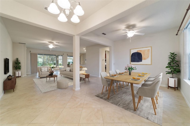 dining area with light tile patterned flooring and ceiling fan with notable chandelier