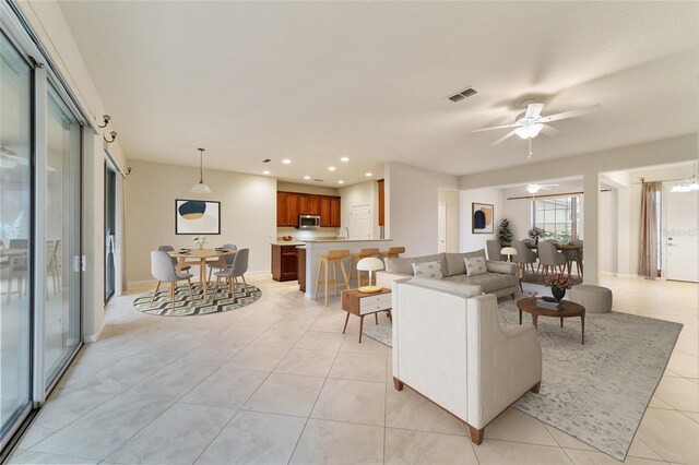 tiled living room featuring ceiling fan