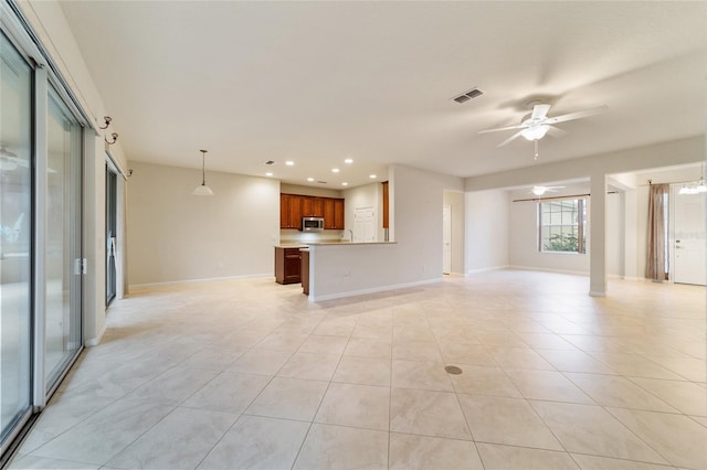 unfurnished living room featuring ceiling fan and light tile patterned floors