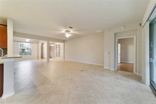 unfurnished living room featuring ceiling fan and light tile patterned floors