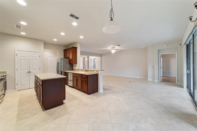 kitchen featuring sink, stainless steel appliances, hanging light fixtures, kitchen peninsula, and light tile patterned floors