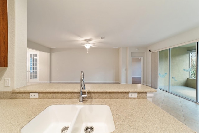 kitchen featuring ceiling fan, sink, and light tile patterned floors