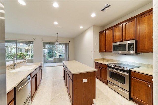 kitchen with a center island, sink, hanging light fixtures, light tile patterned floors, and stainless steel appliances