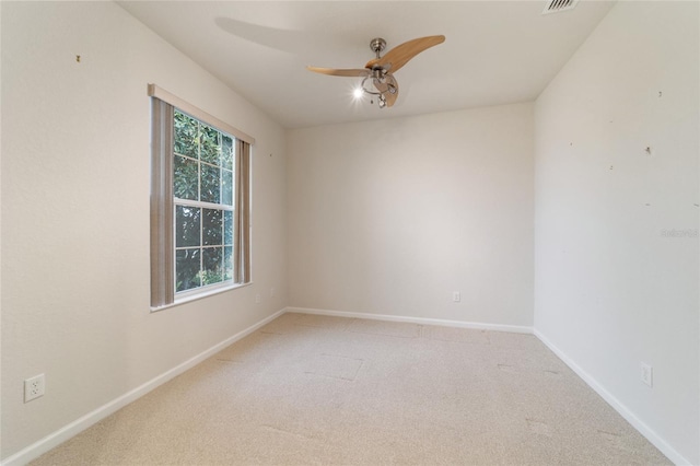 spare room featuring light colored carpet and ceiling fan