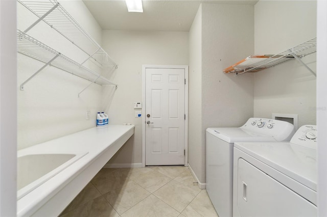 clothes washing area with washer and dryer and light tile patterned floors