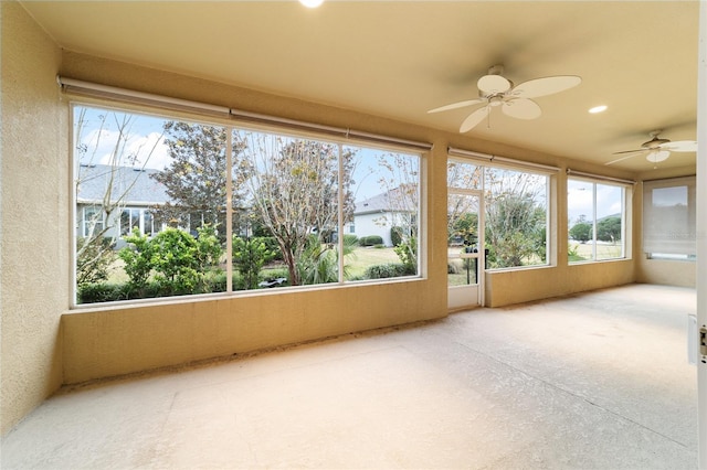 unfurnished sunroom featuring ceiling fan