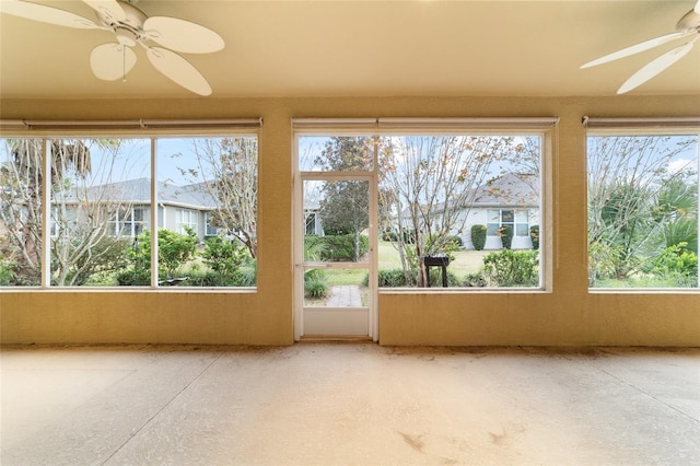 unfurnished sunroom with plenty of natural light and ceiling fan