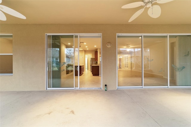 entrance to property with a patio area and ceiling fan