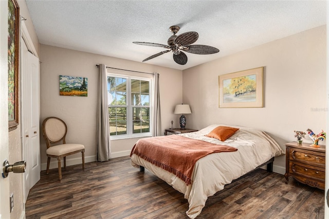 bedroom featuring a textured ceiling, dark hardwood / wood-style flooring, a closet, and ceiling fan