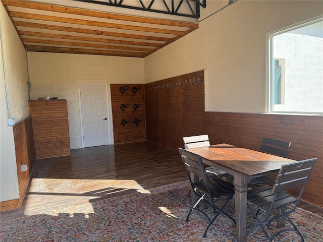 dining area with beam ceiling and dark wood-type flooring