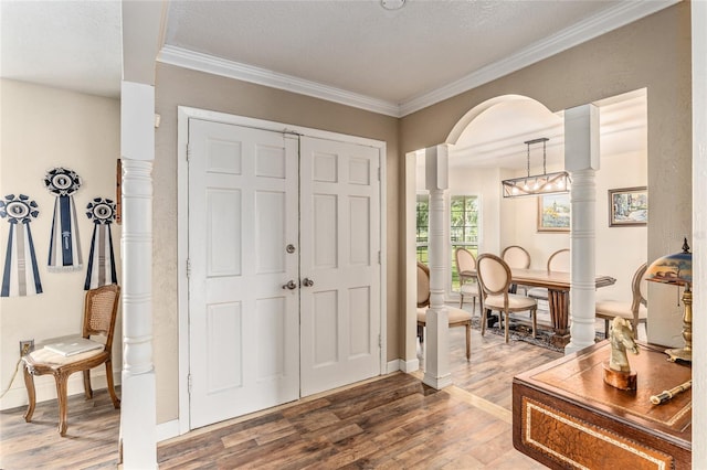 entrance foyer with hardwood / wood-style floors, crown molding, and a textured ceiling