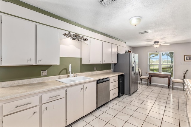 kitchen with sink, ceiling fan, a textured ceiling, white cabinetry, and stainless steel appliances