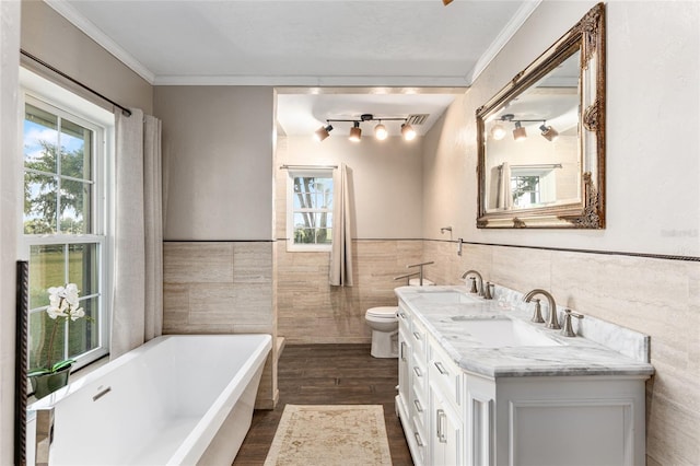 bathroom featuring a tub, toilet, vanity, tile walls, and hardwood / wood-style flooring