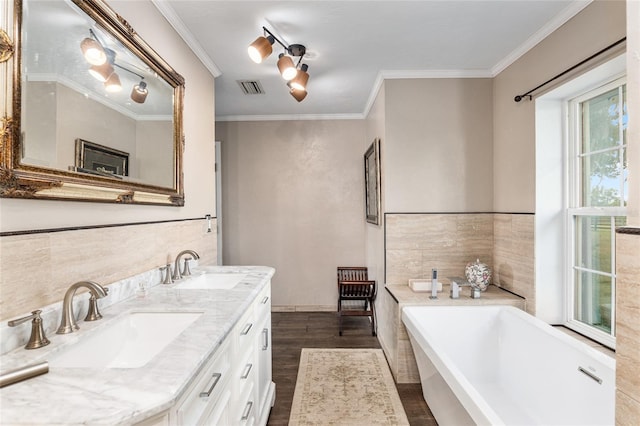 bathroom featuring vanity, wood-type flooring, a tub, and ornamental molding