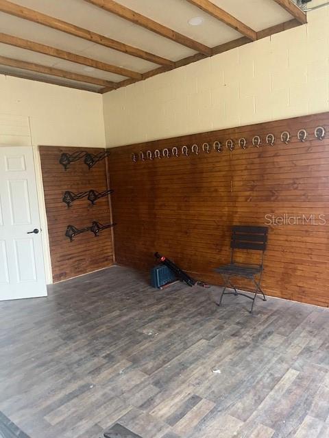 unfurnished room with beam ceiling and dark hardwood / wood-style floors