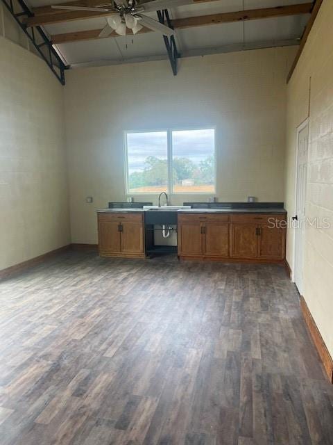 kitchen with ceiling fan, sink, dark hardwood / wood-style flooring, beamed ceiling, and a towering ceiling