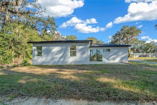 rear view of property featuring a yard