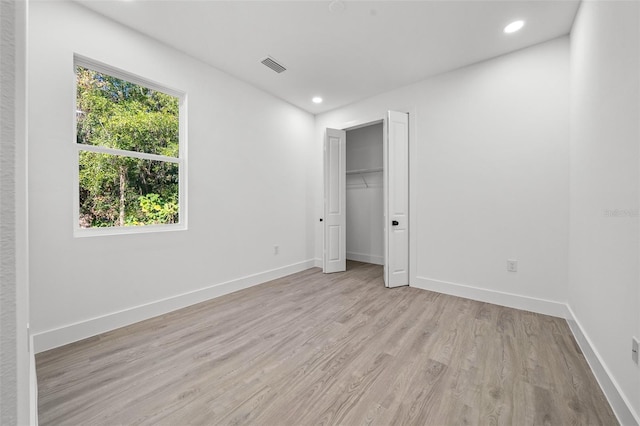 unfurnished bedroom featuring light hardwood / wood-style floors and a closet