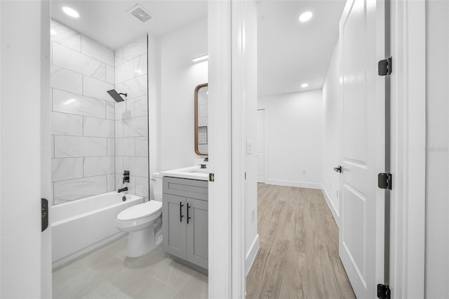 full bathroom featuring vanity, toilet, tiled shower / bath, and hardwood / wood-style flooring