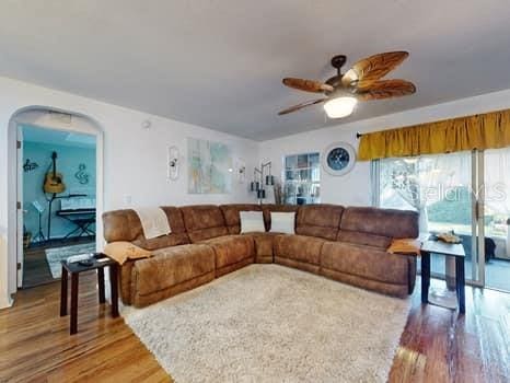 living room featuring ceiling fan and hardwood / wood-style floors