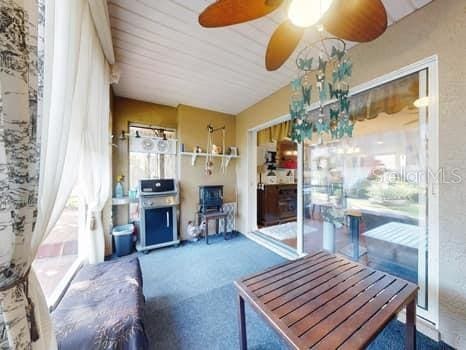 carpeted living room with ceiling fan