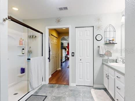 bathroom with vanity and a shower with shower door