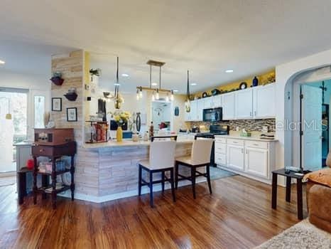 kitchen featuring decorative backsplash, white cabinetry, and dark hardwood / wood-style flooring