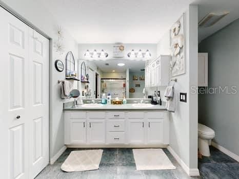 bathroom featuring vanity, toilet, and a shower with door