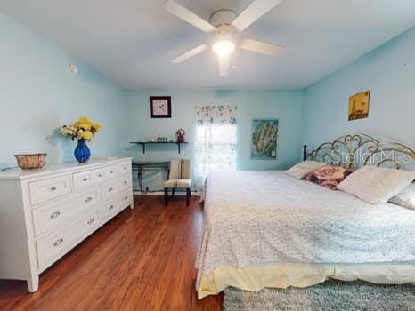 bedroom with ceiling fan and dark hardwood / wood-style floors