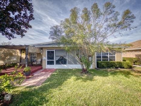 rear view of house featuring a yard and a patio