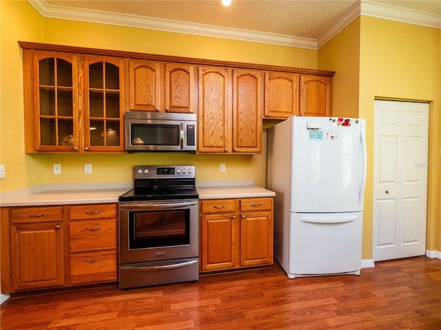 kitchen featuring appliances with stainless steel finishes, a textured ceiling, dark hardwood / wood-style floors, and ornamental molding