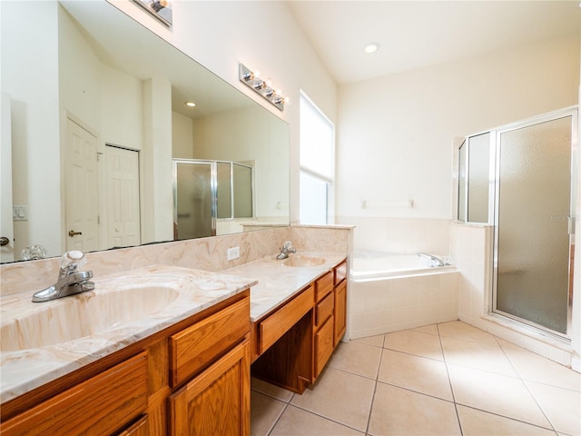 bathroom with tile patterned floors, vanity, and shower with separate bathtub