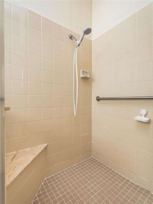 bathroom with tile patterned floors and tiled shower