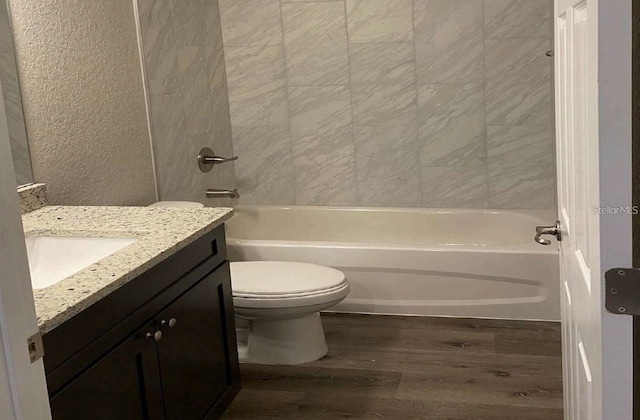 full bathroom with bathing tub / shower combination, toilet, vanity, and hardwood / wood-style flooring