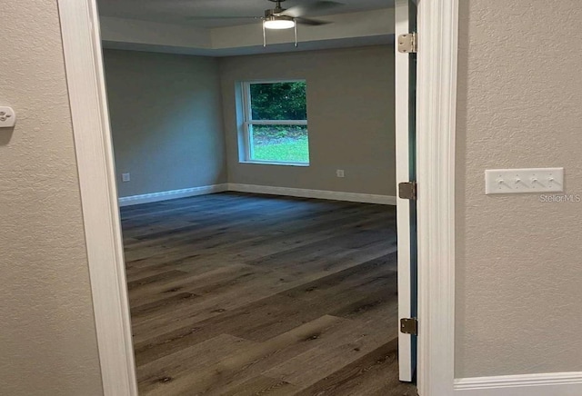 spare room featuring ceiling fan and dark wood-type flooring