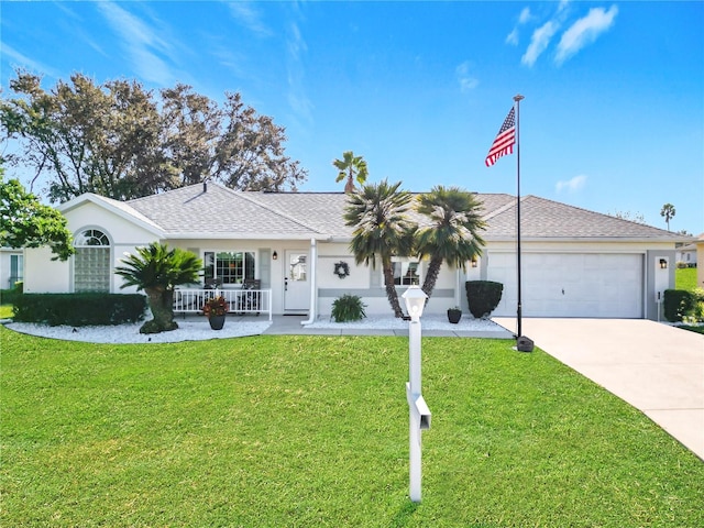 ranch-style home with covered porch, a front yard, and a garage