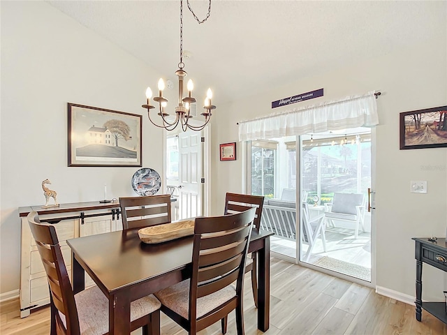 dining area with light hardwood / wood-style floors and a chandelier