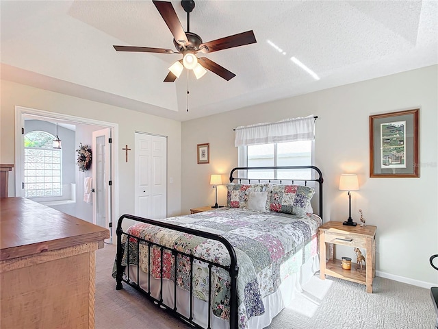 carpeted bedroom featuring ceiling fan, a closet, and a textured ceiling