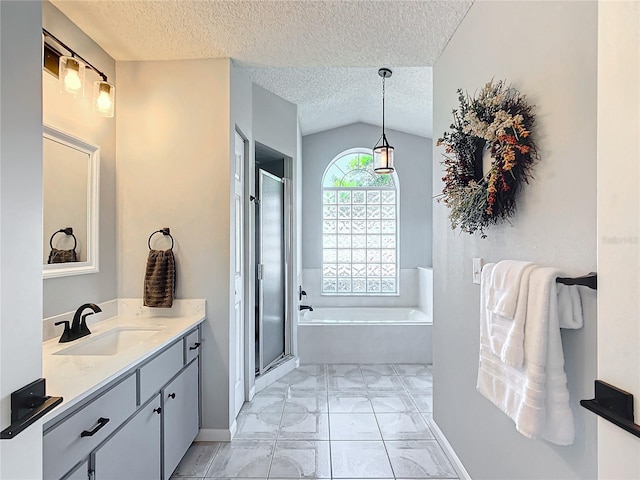 bathroom featuring a textured ceiling, plus walk in shower, vanity, and lofted ceiling