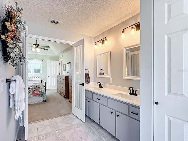 bathroom featuring ceiling fan, vanity, and a textured ceiling